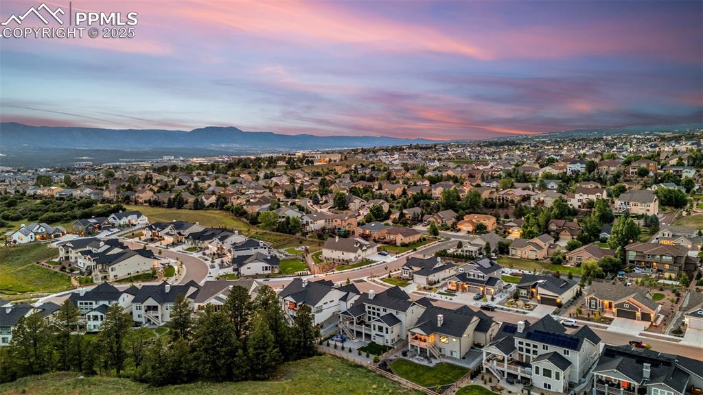 Image 34 of 35: Aerial view at dusk of a residential view and a mountain view