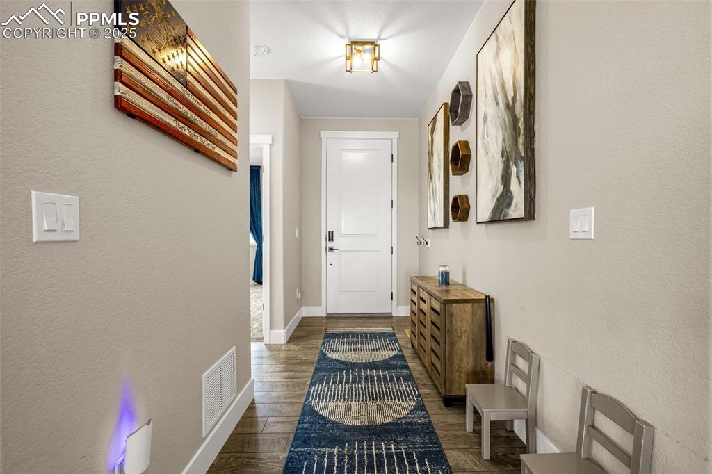 Image 4 of 35: Doorway to outside with wood finished floors and baseboards