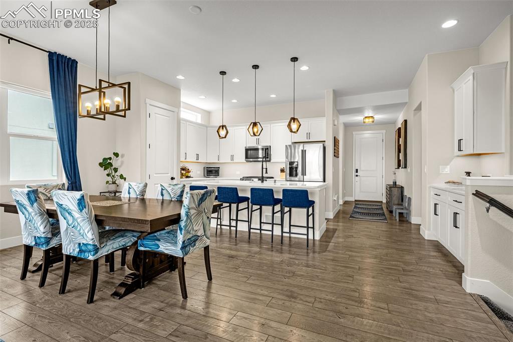 Image 6 of 35: Dining space featuring a chandelier, dark wood-type flooring, and recessed 