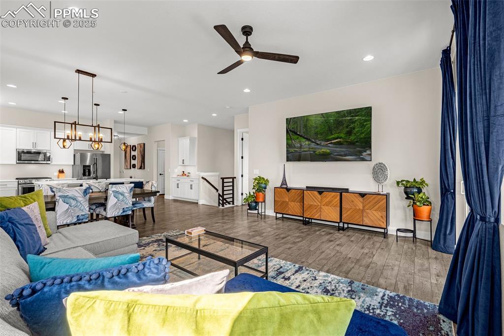 Image 9 of 35: Living area with a ceiling fan, wood finished floors, a chandelier, and rec