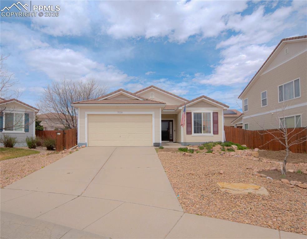 Image 2 of 17: Single-story residence featuring light-colored siding, an attached garage, 