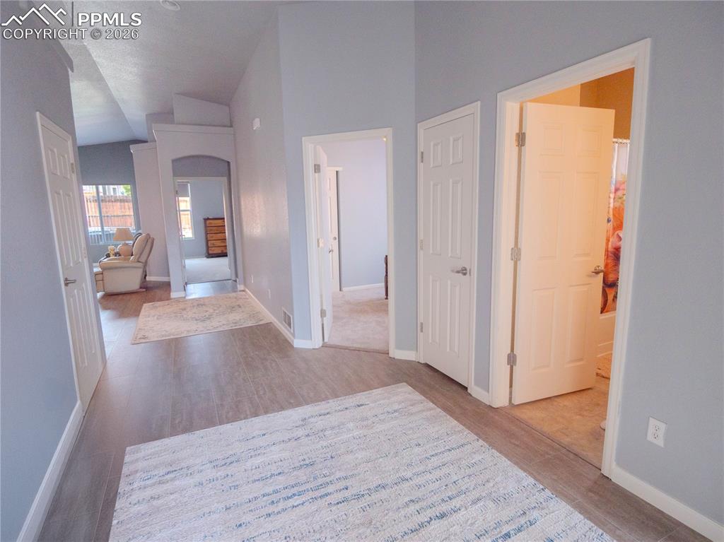 Image 4 of 17: Hallway featuring wood-finish flooring, light grey wall paint, and white tr