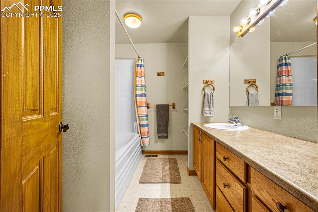 Image 13 of 36: Full bathroom featuring vanity, shower / bath combination with curtain, and