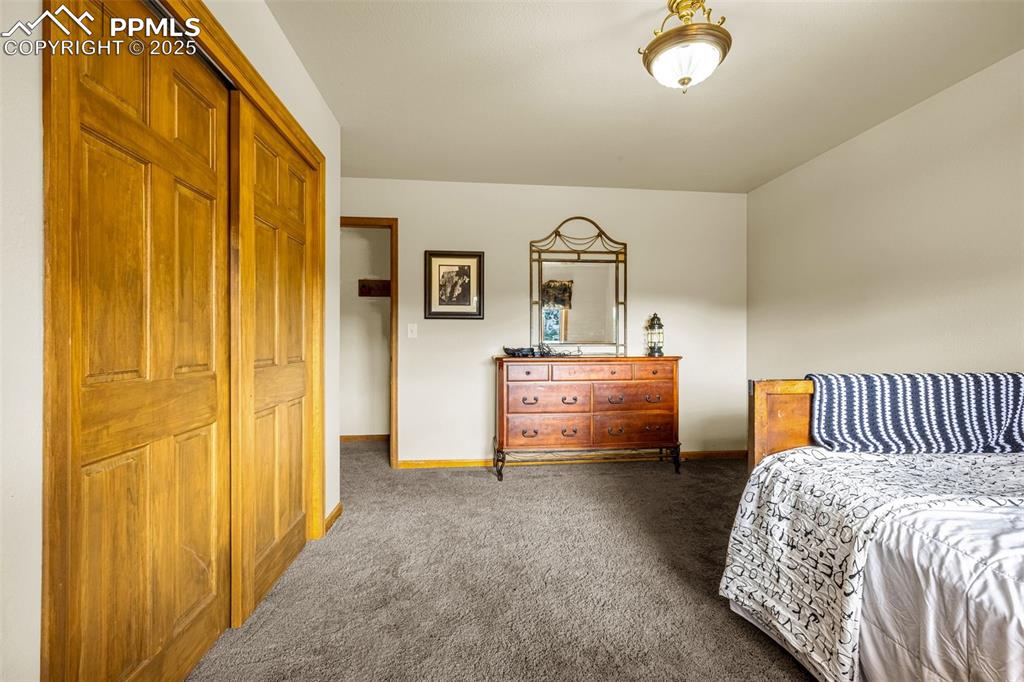 Image 18 of 36: Bedroom 3 with dark carpet and a closet
