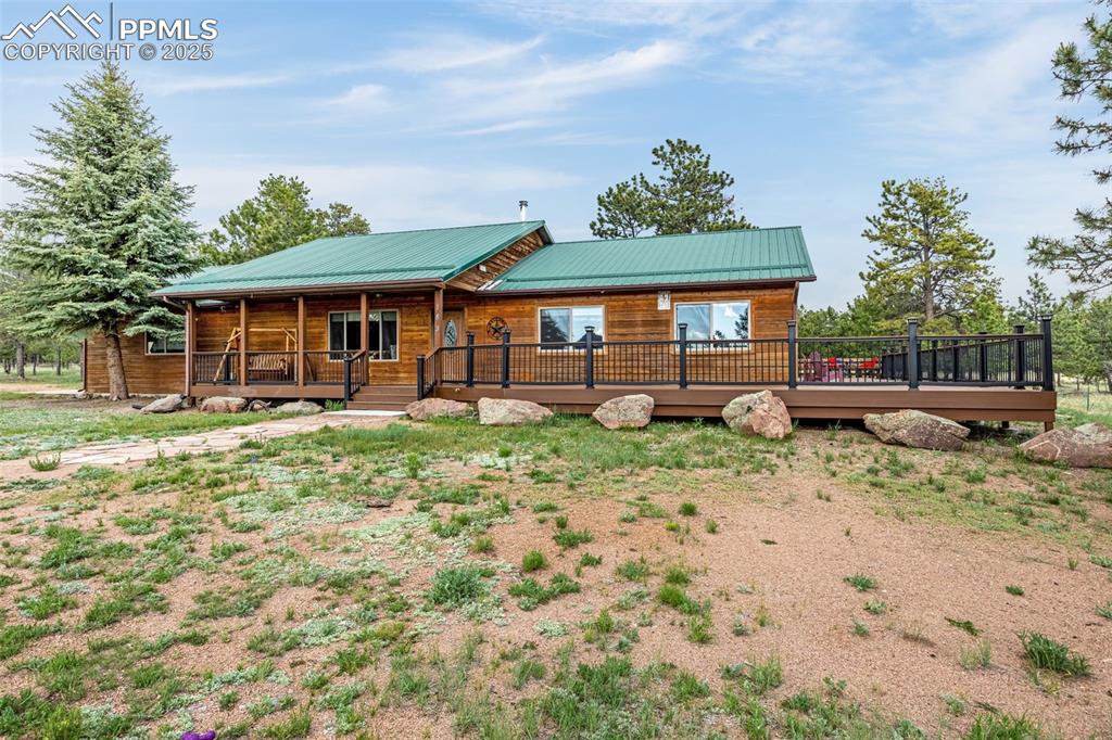 Image 2 of 36: View of front of house with a metal roof and a porch