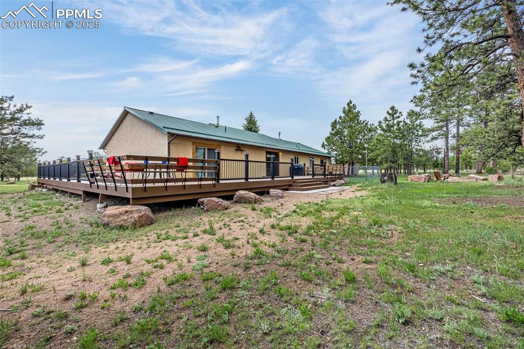Image 27 of 36: Rear view of house featuring a deck and a metal roof