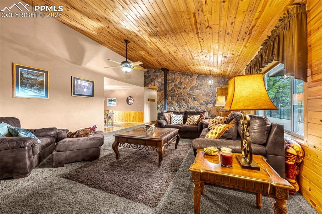 Image 4 of 36: Carpeted living room with wood ceiling, a ceiling fan, lofted ceiling, and