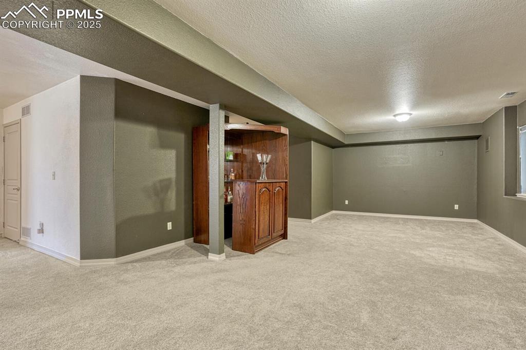 Image 44 of 50: The Basement Recreation Room offers a TV area and dry bar for serving your
