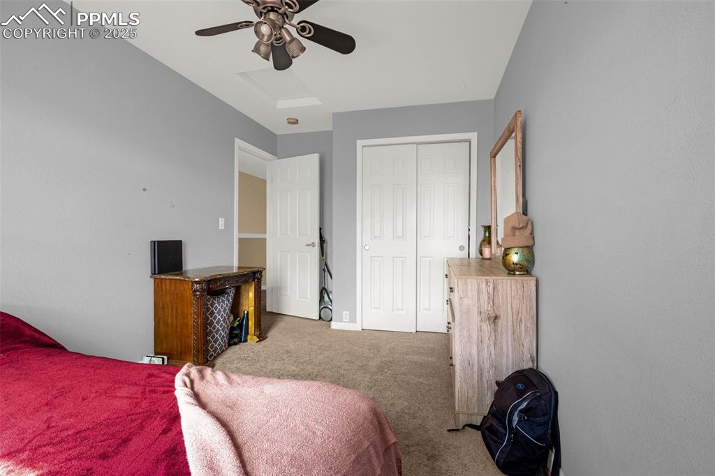 Image 10 of 23: Carpeted bedroom with a closet, ceiling fan, and attic access