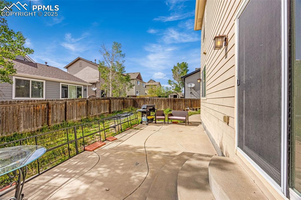 Image 20 of 23: Fenced backyard featuring grilling area, a patio, and a residential view