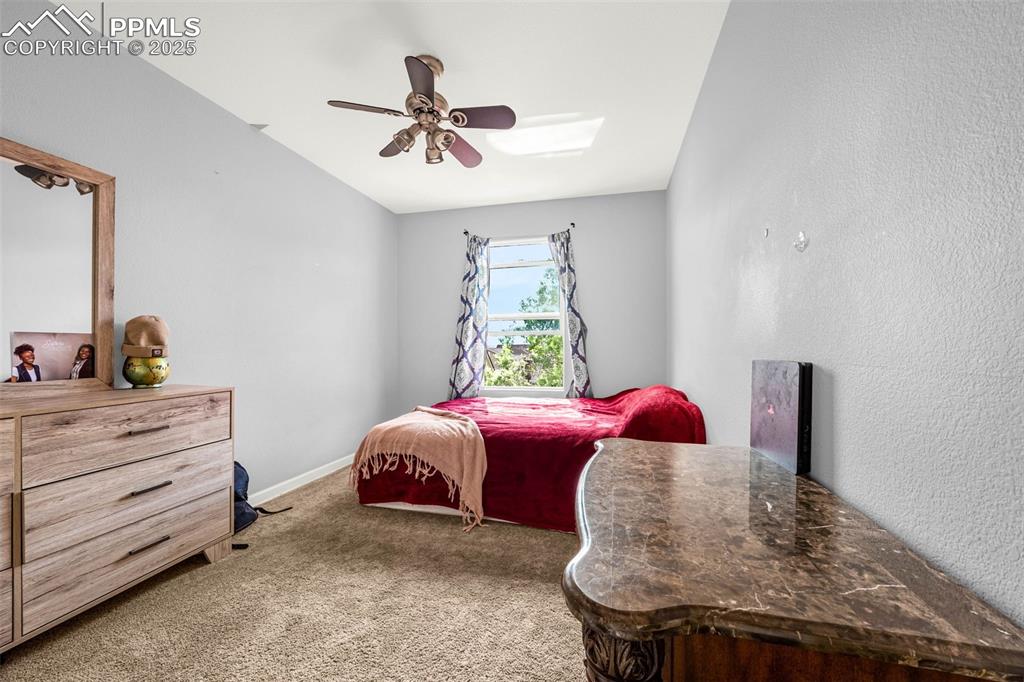 Image 9 of 23: Carpeted bedroom with a ceiling fan and a skylight