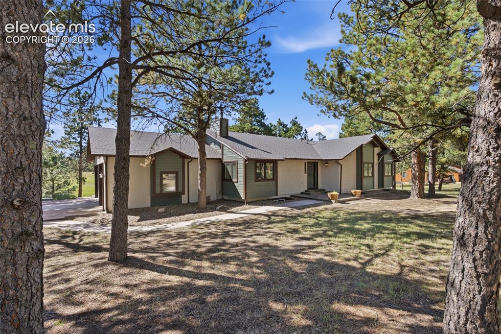 Caption: Single-story residence featuring a neutral stucco exterior with contrasting dark trim, a covered ent