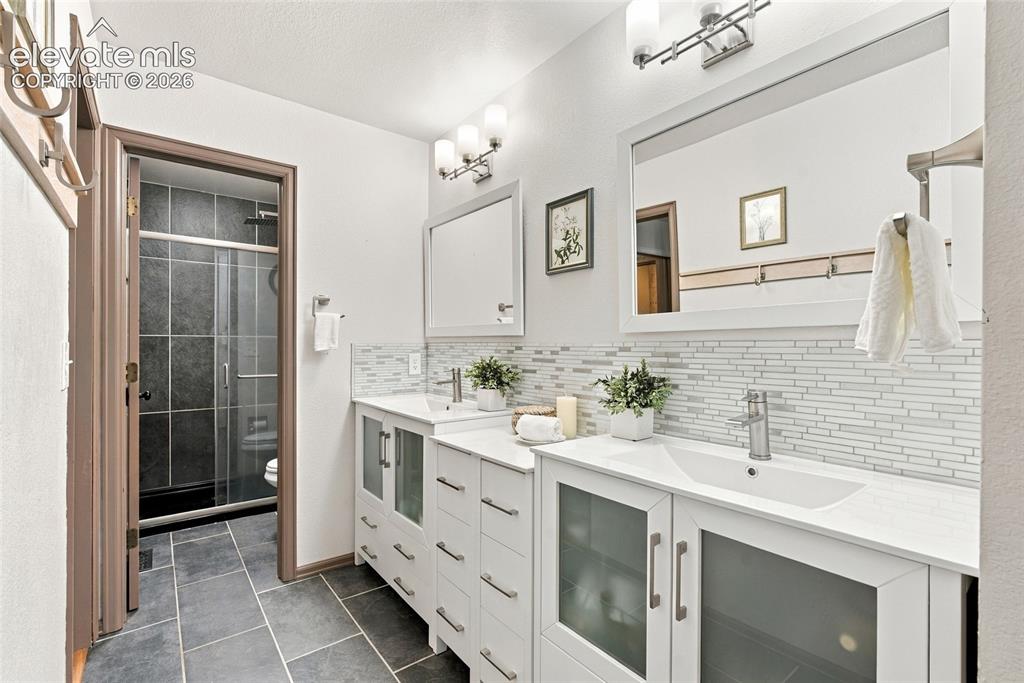 Image 13 of 37: Primary Bathroom Dual white vanities with integrated sinks, contemporary wa