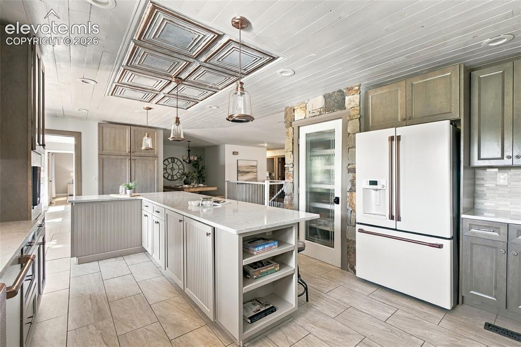 Image 4 of 37: Kitchen featuring a textured ceiling with decorative tin panel inlay, reces