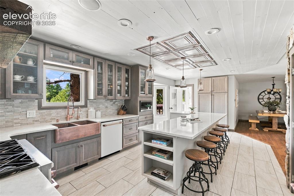 Image 5 of 37: Kitchen featuring custom gray cabinetry, a double basin copper farmhouse si