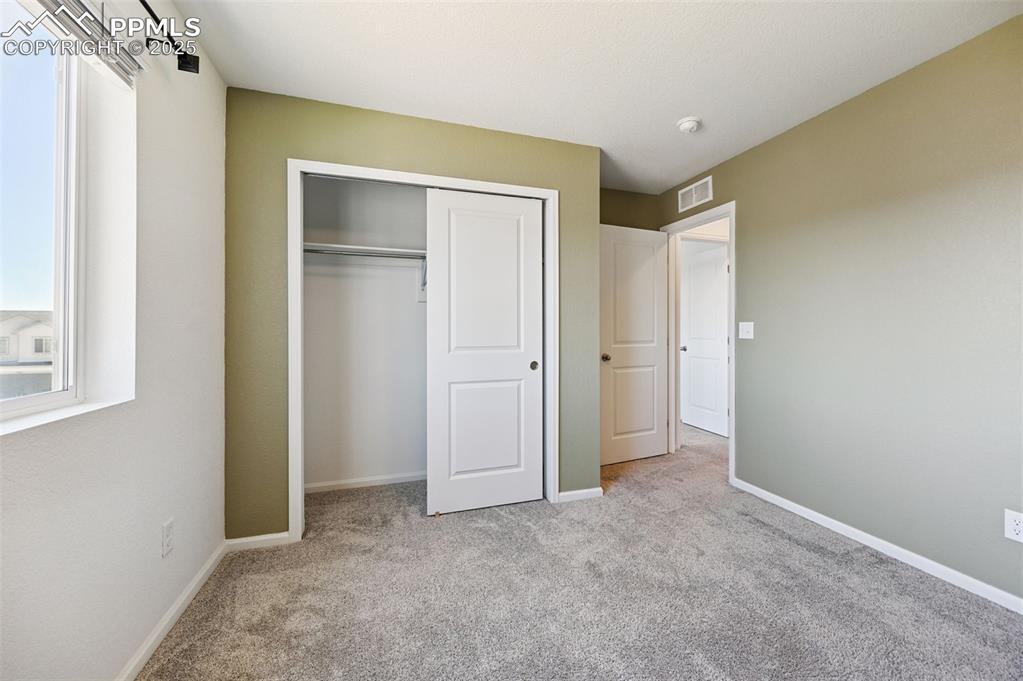 Image 14 of 24: Unfurnished bedroom with carpet flooring and a closet