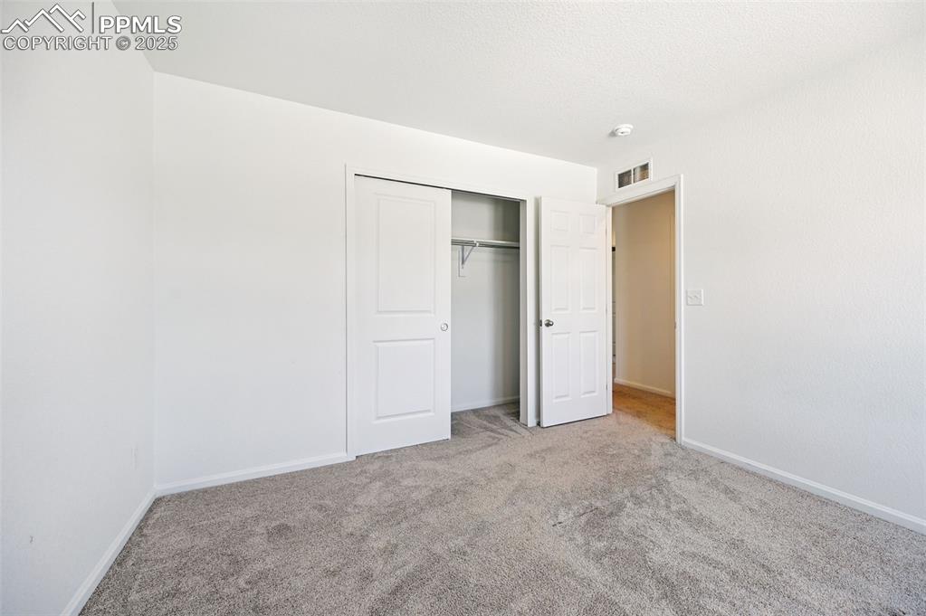 Image 16 of 24: Unfurnished bedroom with carpet and a closet