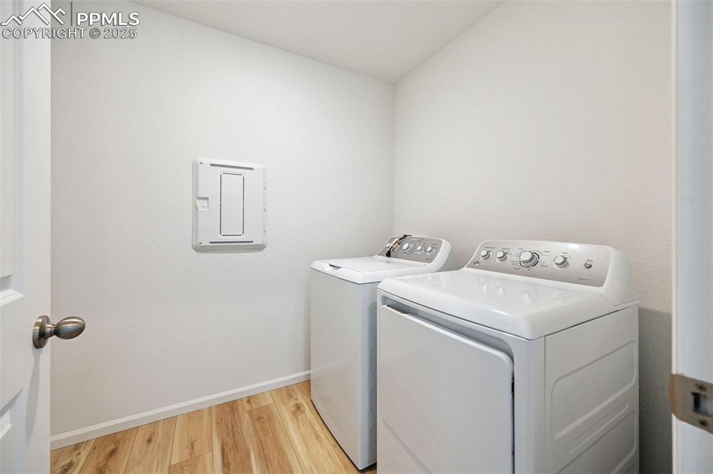 Image 17 of 24: Laundry area featuring independent washer and dryer and light wood-type flo