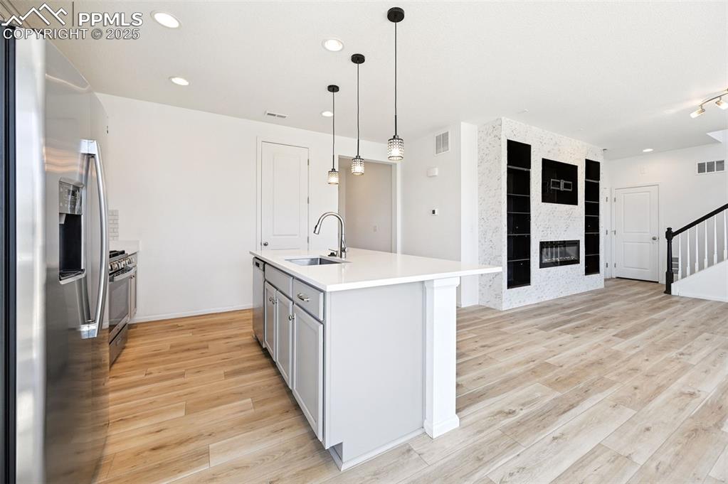 Image 6 of 24: Kitchen with appliances with stainless steel finishes, light wood-style flo