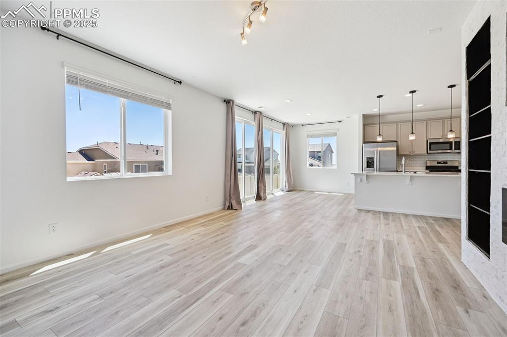 Image 9 of 24: Unfurnished living room featuring light wood-style floors, healthy amount o