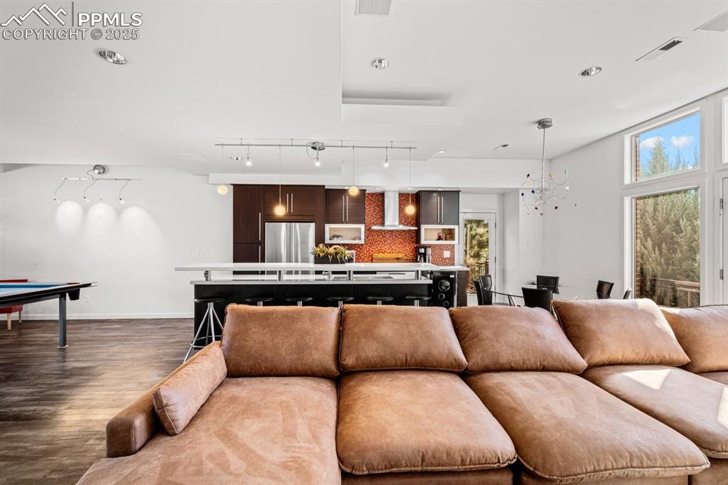 Image 12 of 41: Living room featuring wood finished floors, recessed lighting, track lighti