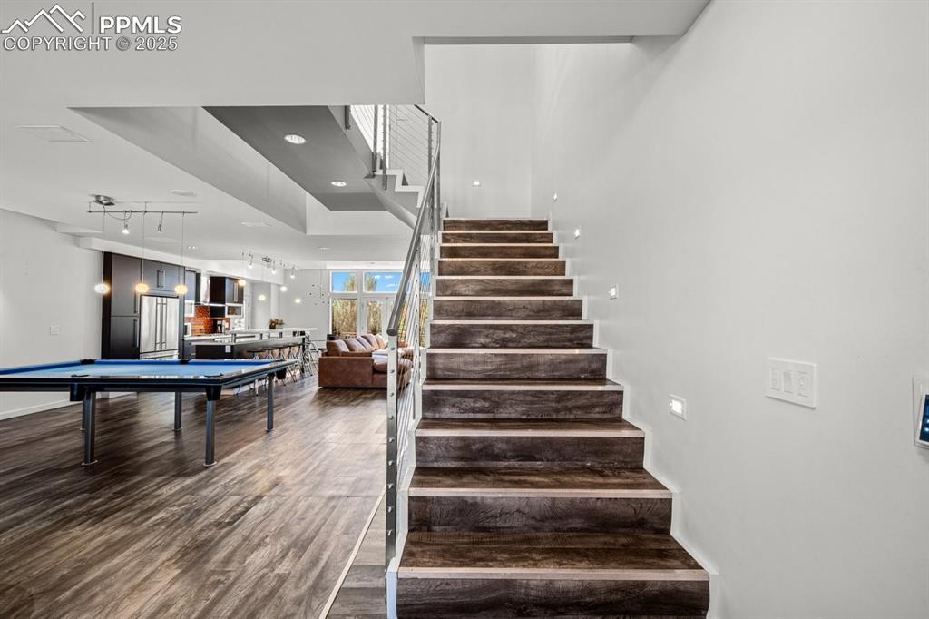 Image 15 of 41: Stairway featuring billiards table, wood finished floors, and recessed ligh