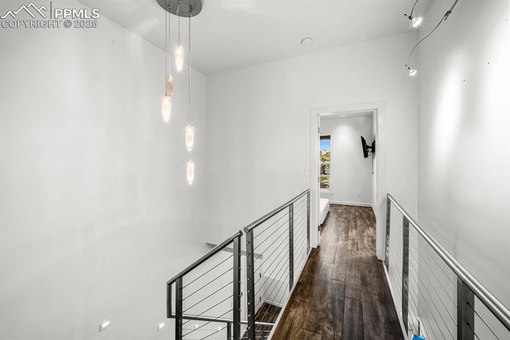 Image 17 of 41: Hallway with dark wood-type flooring and an upstairs landing