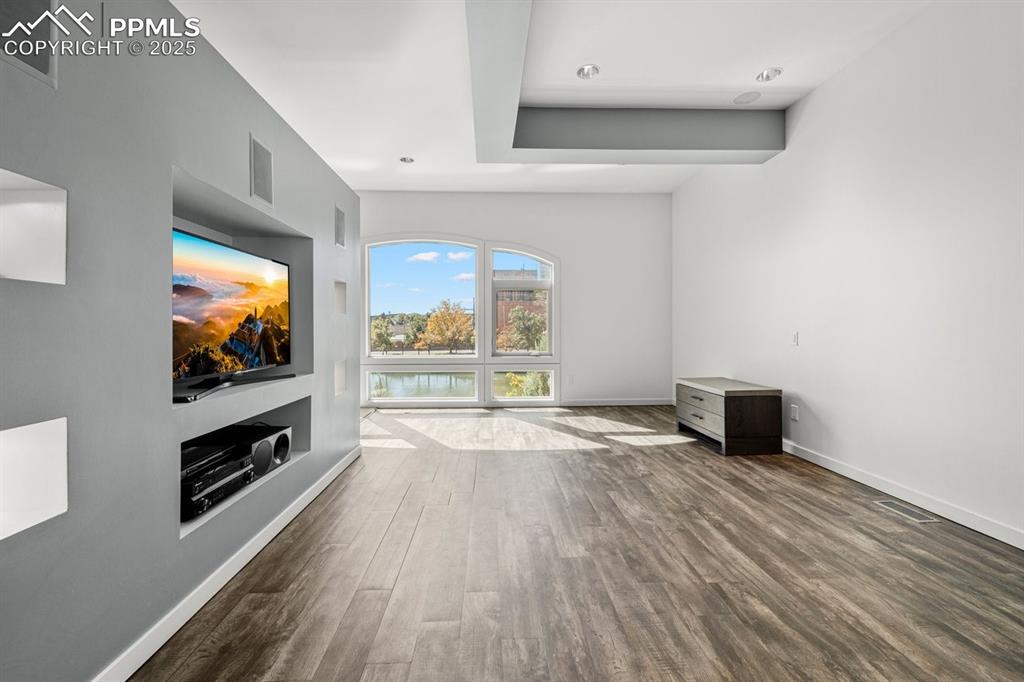Image 23 of 41: Unfurnished living room featuring dark wood finished floors and baseboards
