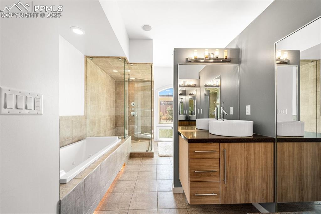 Image 25 of 41: Full bath featuring a tub with jets, vanity, light tile patterned floors, a