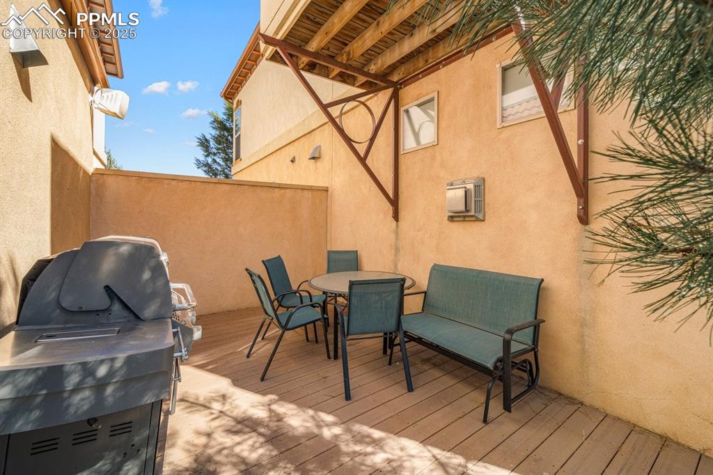 Image 31 of 41: Wooden terrace with outdoor dining space and grilling area
