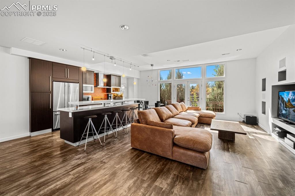 Image 5 of 41: Living room featuring dark wood finished floors, built in shelves, and a ch