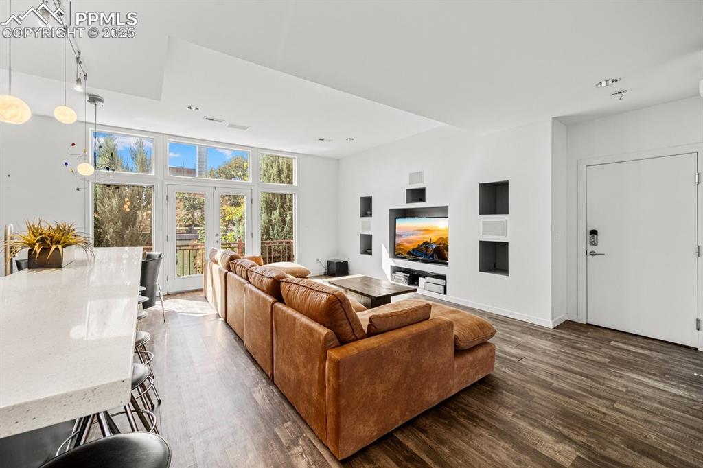 Image 7 of 41: Living area featuring dark wood-style floors, french doors, and recessed li