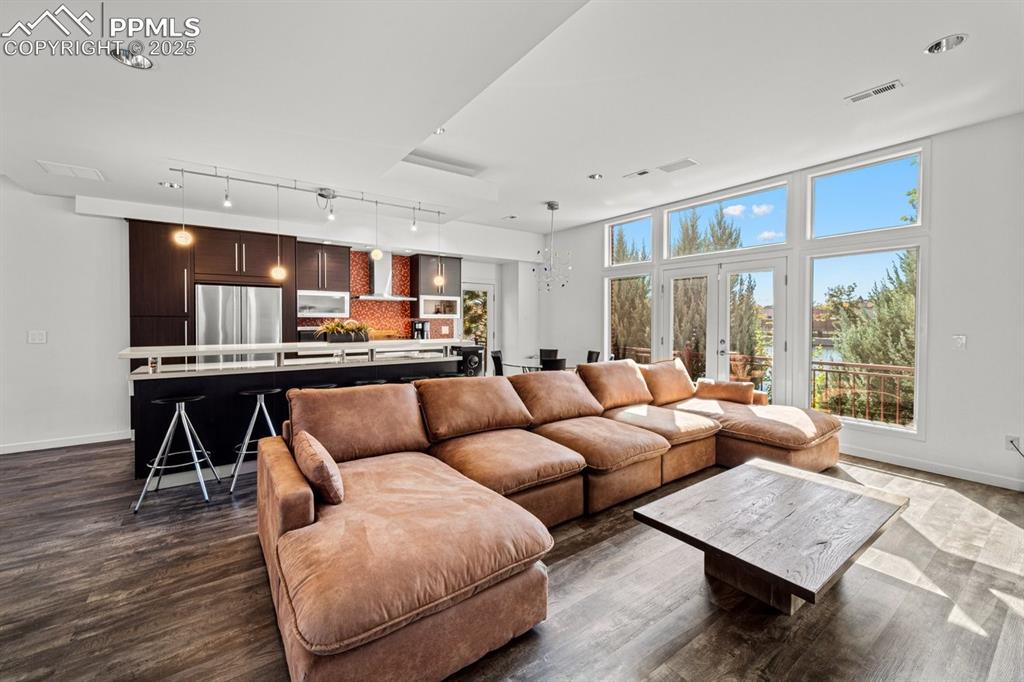 Image 8 of 41: Living room with rail lighting, a chandelier, and dark wood-style floors