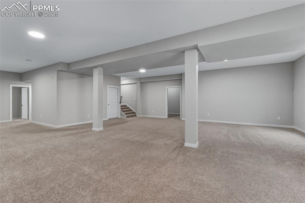 Image 31 of 50: Finished below grade area featuring light carpet, stairs, and recessed ligh