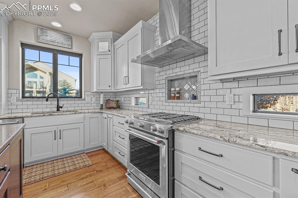 Image 15 of 46: Kitchen featuring stainless steel appliances and wall chimney range hood.