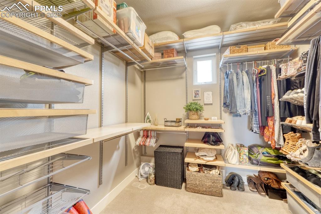Image 20 of 46: Primary Walk in closet featuring custom built in shelving