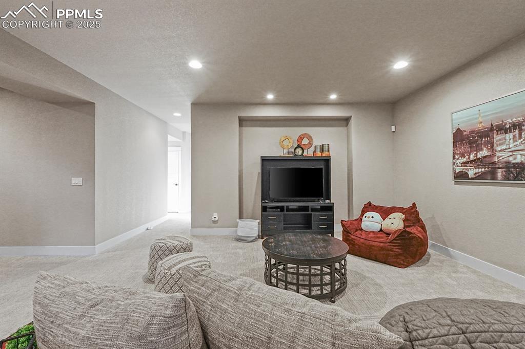 Image 25 of 46: Living area featuring carpet flooring, recessed lighting, and a textured ce