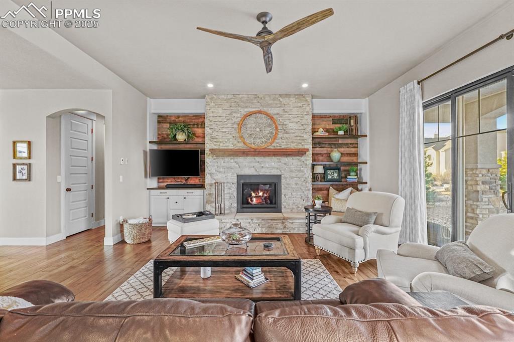 Image 3 of 46: Living area featuring arched walkway stone hearth with built in shelves