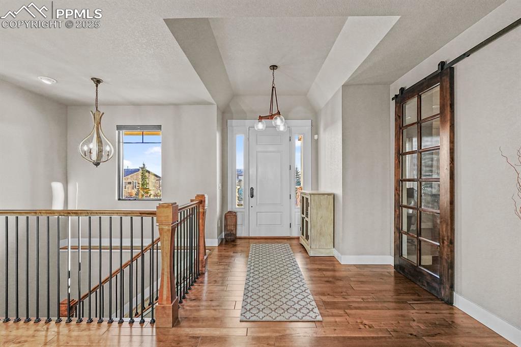 Image 8 of 46: Entryway with hardwood floors and a barn door to bonus room