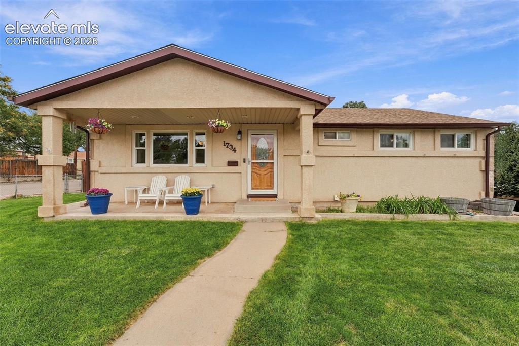 Image 1 of 48: Stucco exterior with a covered front porch, asphalt shingle roof, and a woo