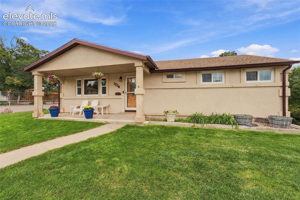 Image 2 of 48: Stucco exterior with a covered porch entry, pitched roof, and a concrete wa