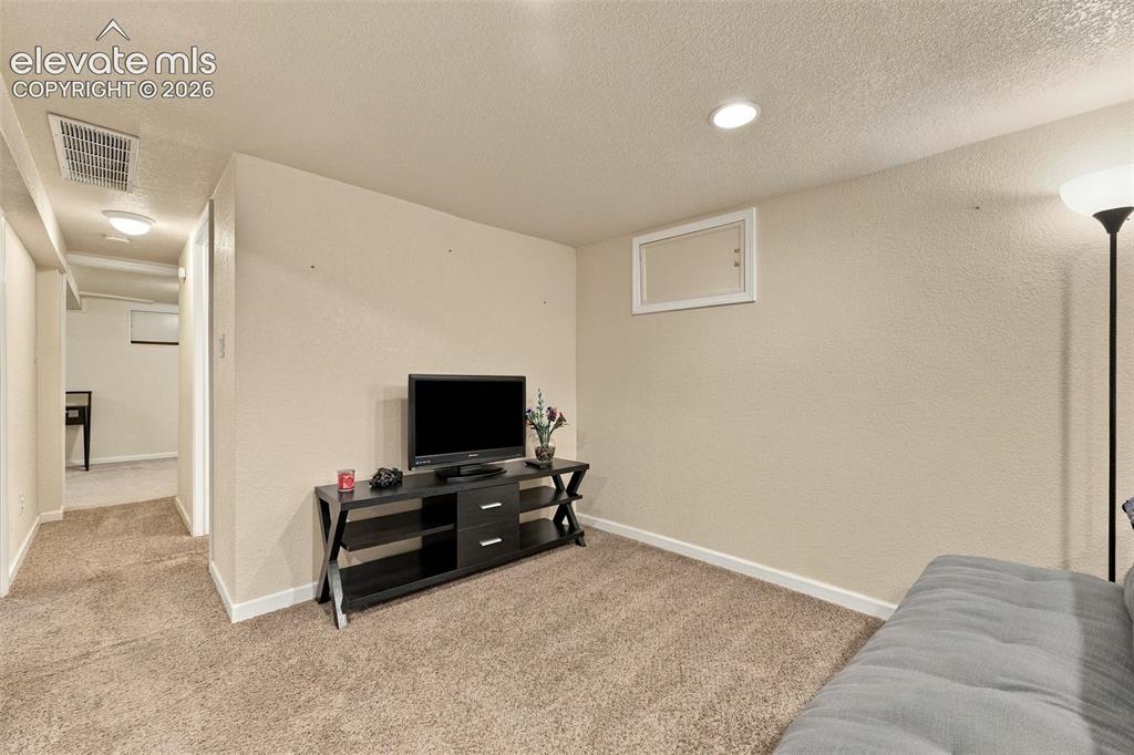 Image 28 of 48: Recessed ceiling lighting, textured wall finish, and carpet flooring