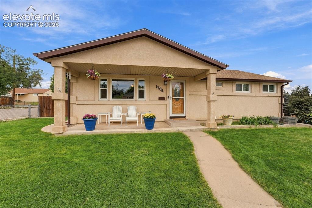 Image 3 of 48: Stucco exterior with a covered front porch, concrete walkway, and a gable r
