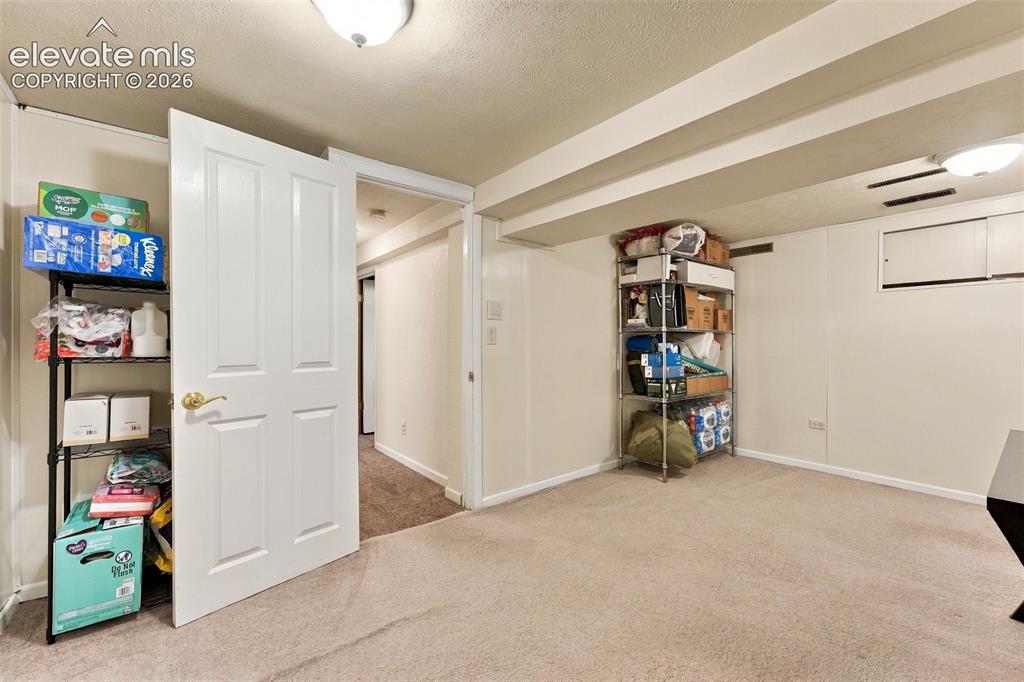 Image 33 of 48: Recessed ceiling lighting, exposed structural beams, wall-to-wall carpeting
