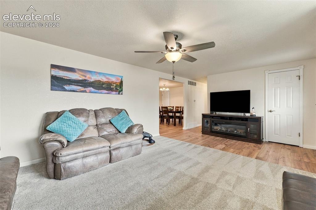 Image 8 of 48: Neutral wall color, ceiling fan, wood-finish flooring, white paneled door, 