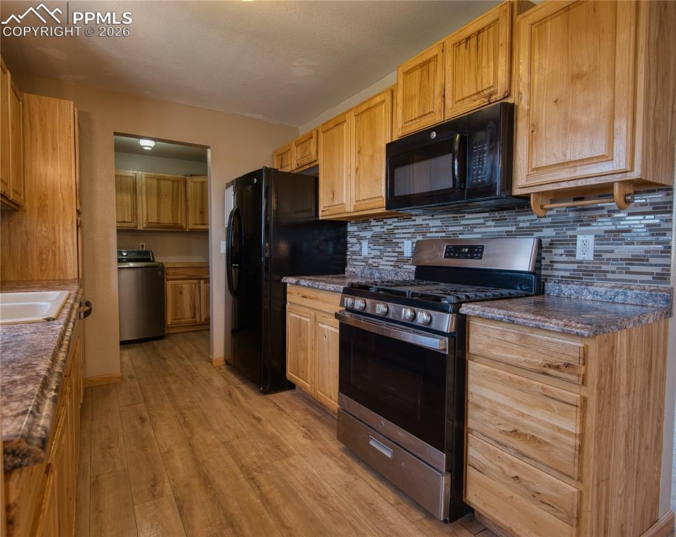 Image 4 of 27: Side by side refrigerator, stainless steel gas range and microwave included