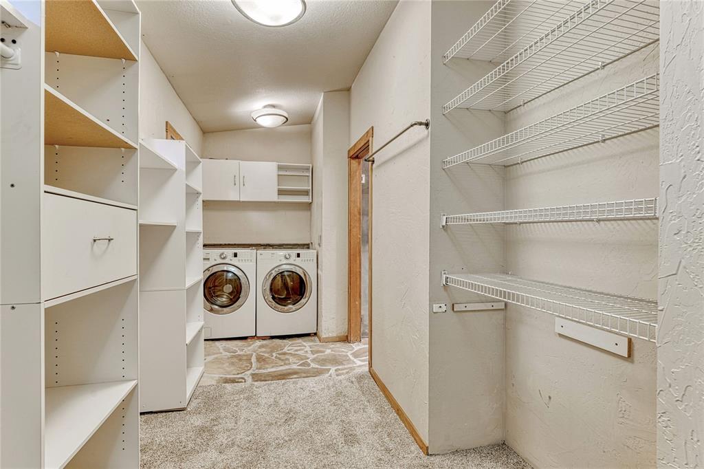 Image 18 of 49: Primary closet connects to laundry room