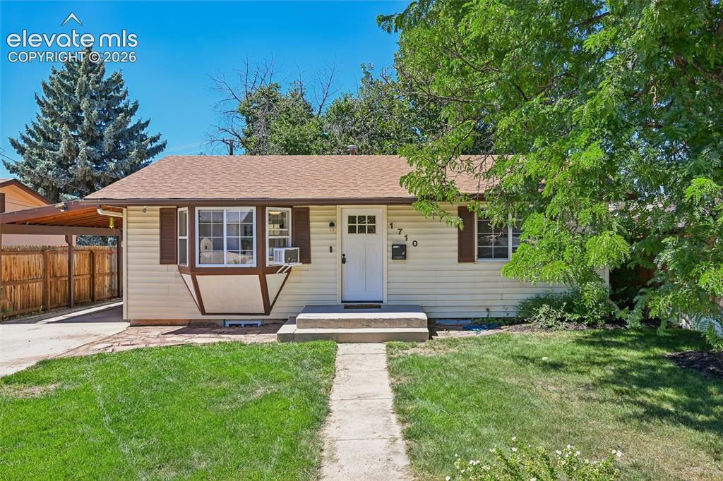Caption: Landscaped yard facing carport 