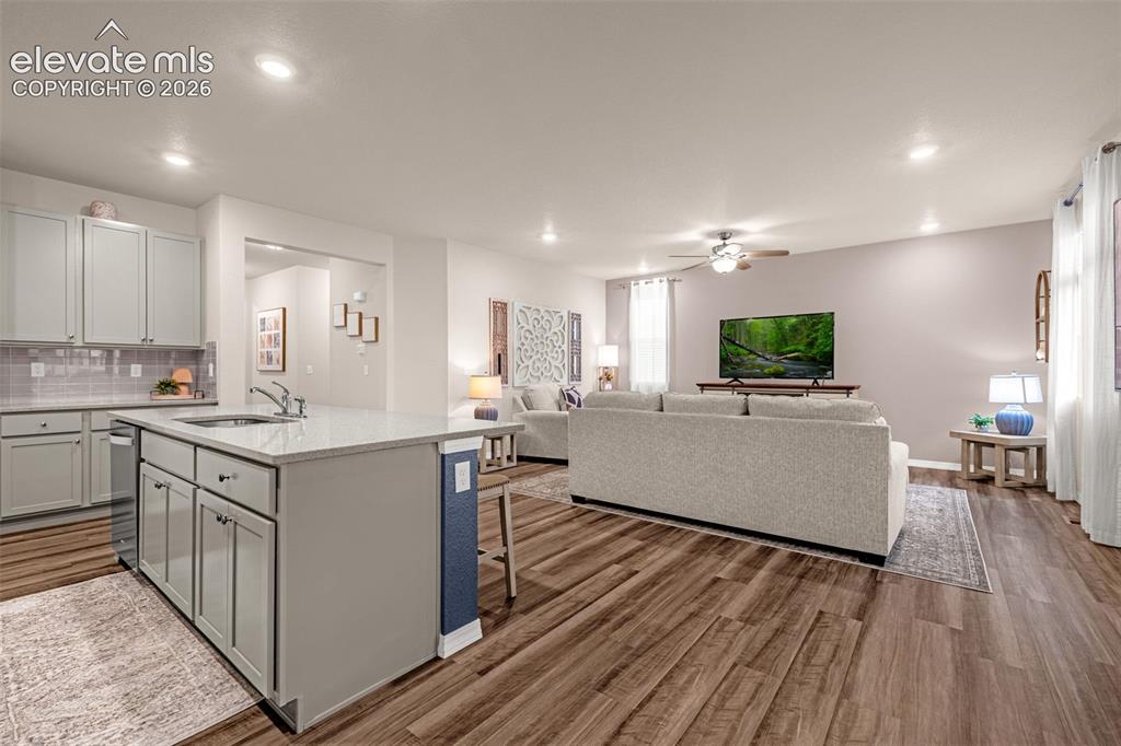 Image 10 of 40: Open-concept living area featuring wood-finish flooring, recessed lighting,