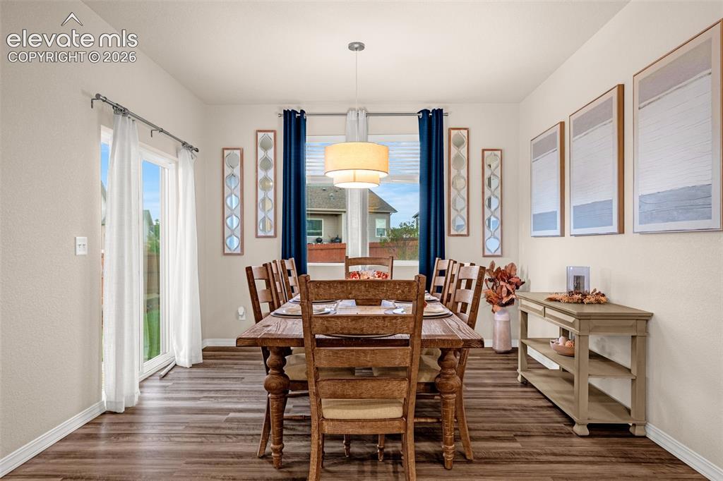Image 11 of 40: Dining area featuring wood-finish flooring, a contemporary ceiling light fi